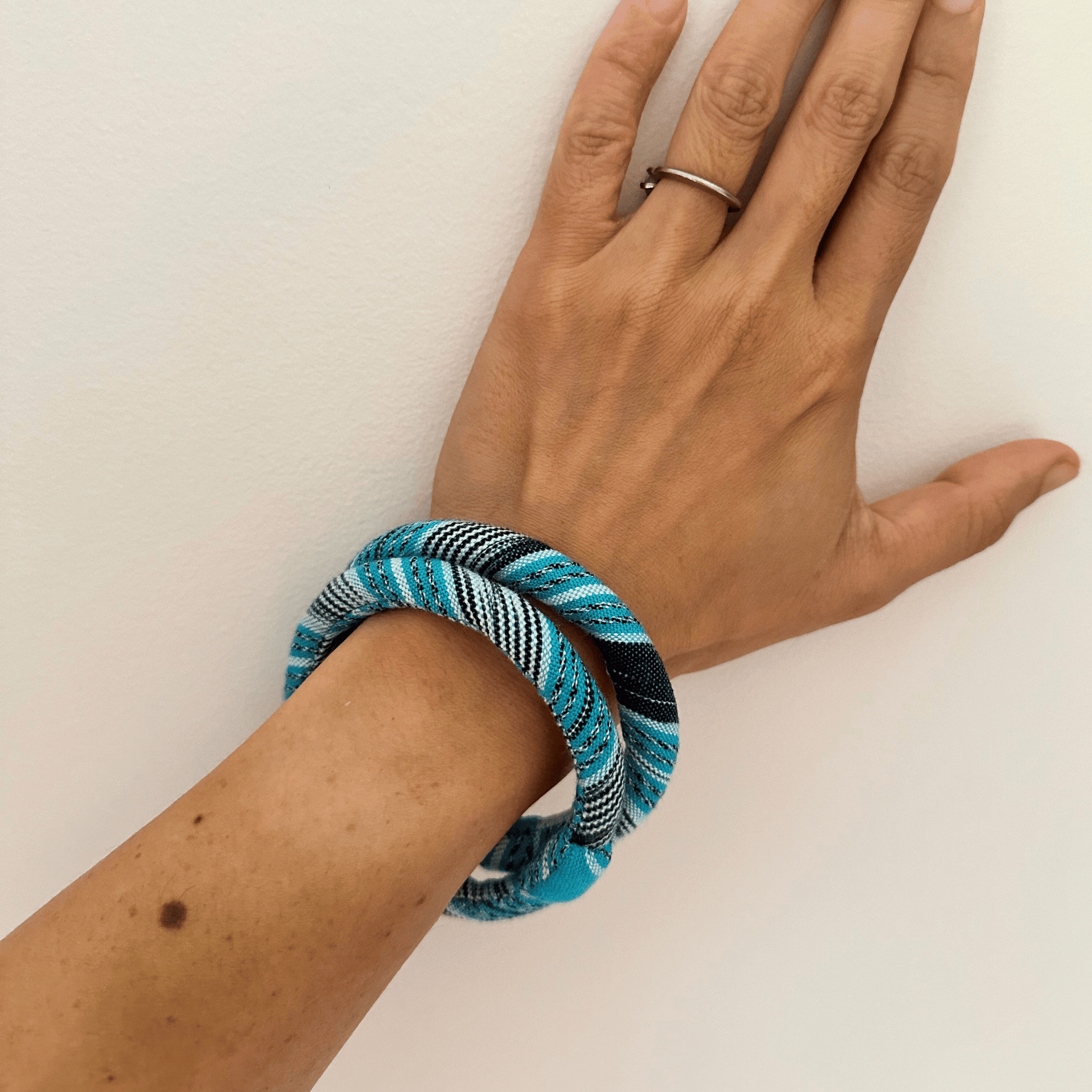 textile bangles in light blue on upper hand