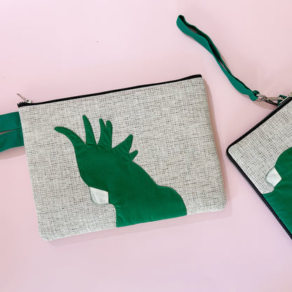 jute cockatoo clutch in green on pink background