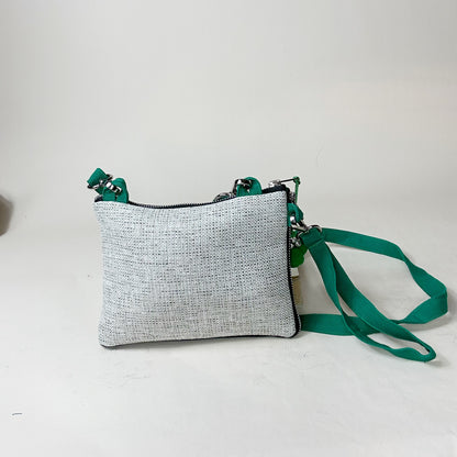 Gray textured crossbody bag with a green strap on a light gray background