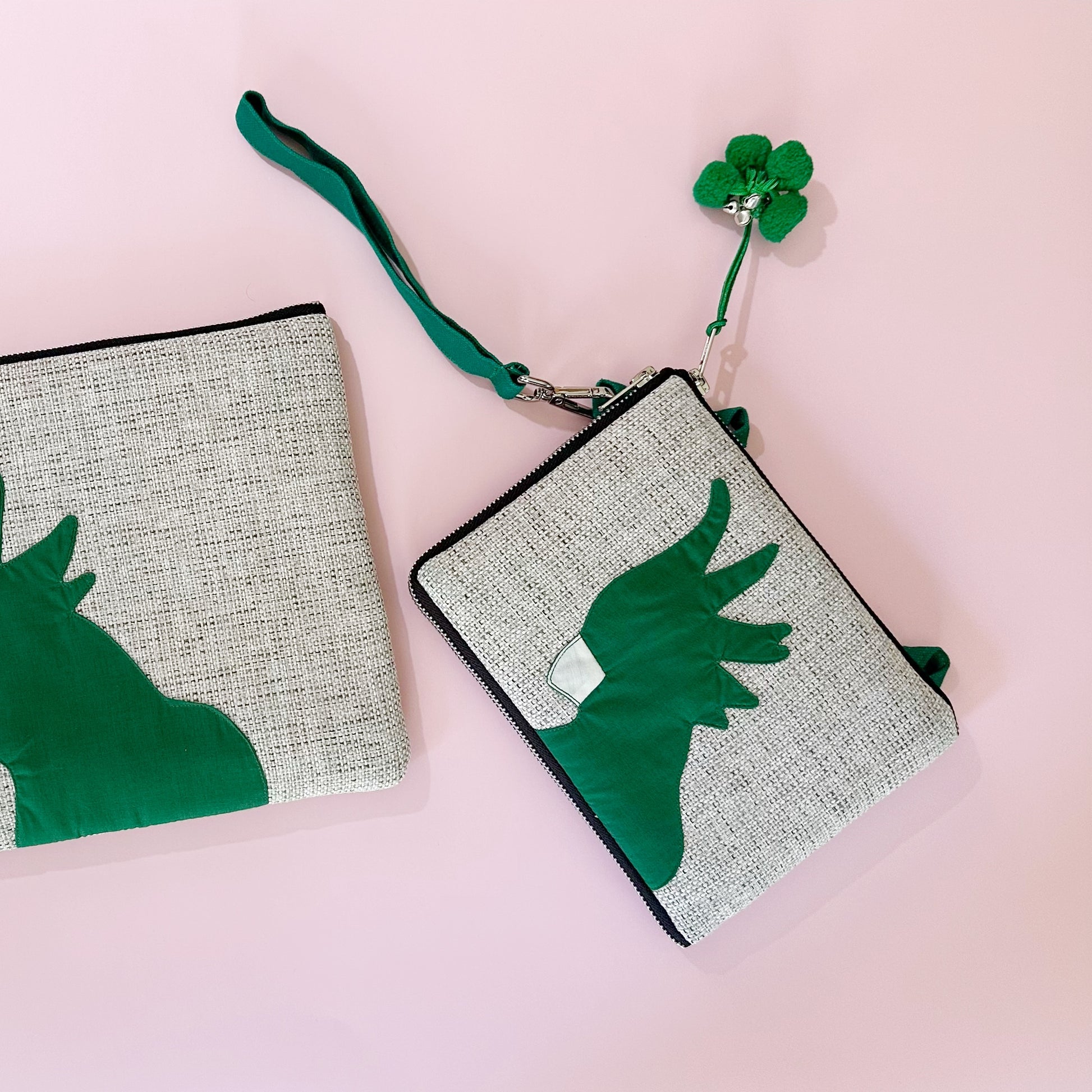jute cockatoo crossbody bag in green flatlay next to clutch